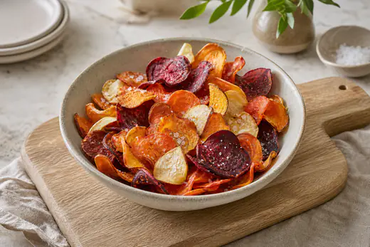 Bol de chips de légumes croustillantes colorées, patate douce orange, betterave rouge, panais et carotte, avec du sel en fleur