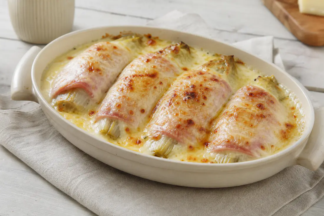 Endives enroulées de jambon blanc, nappées de béchamel et gratinées au gruyère dans un petit plat ovale