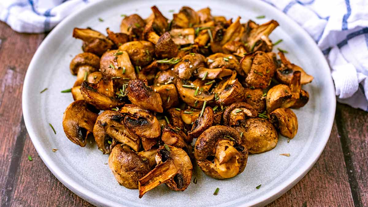 Champignons grillés cuits dans l'airfryer, servis dans une assiette.