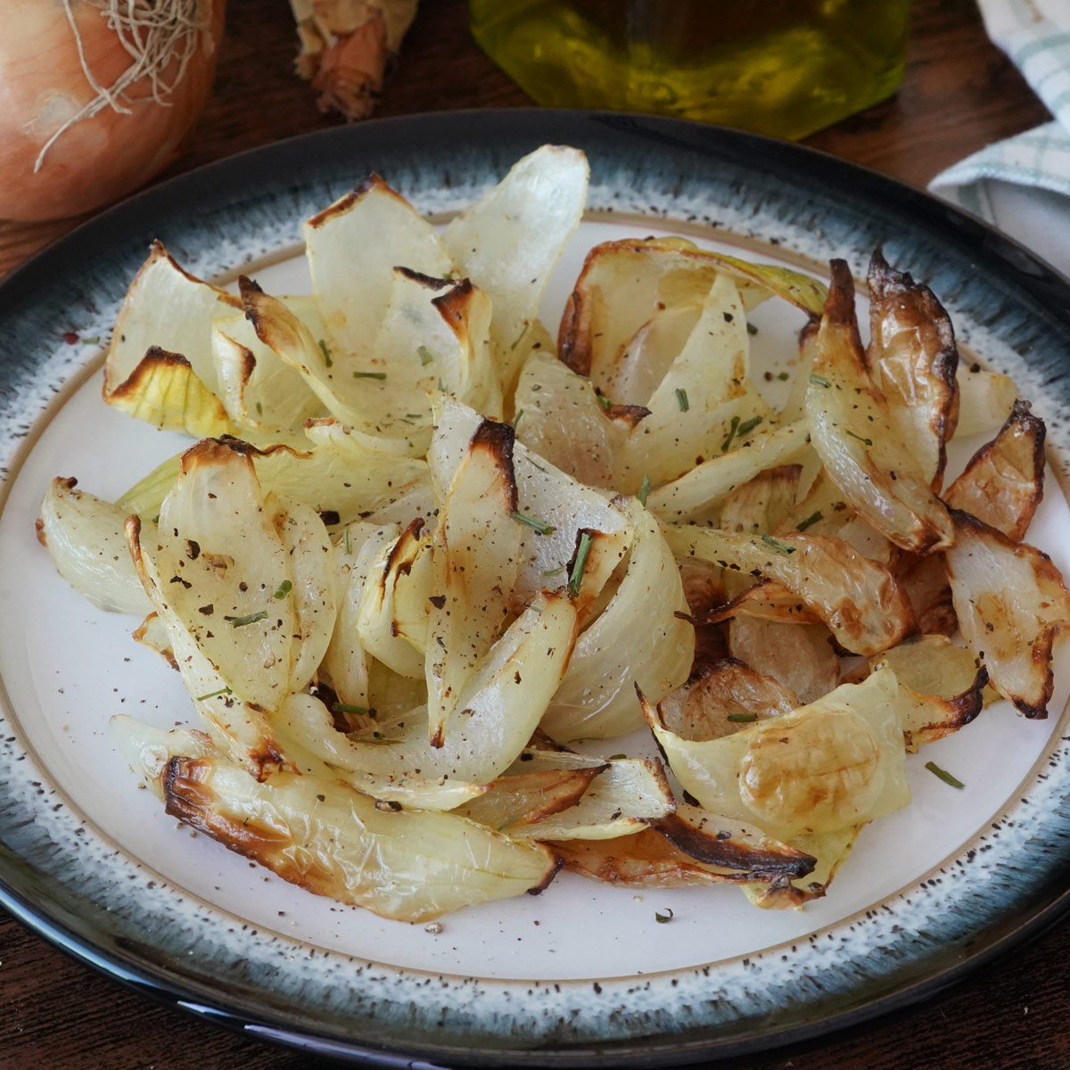 Rondelles d'oignons dorées et caramélisées, cuites dans l'airfryer, servies dans une assiette.