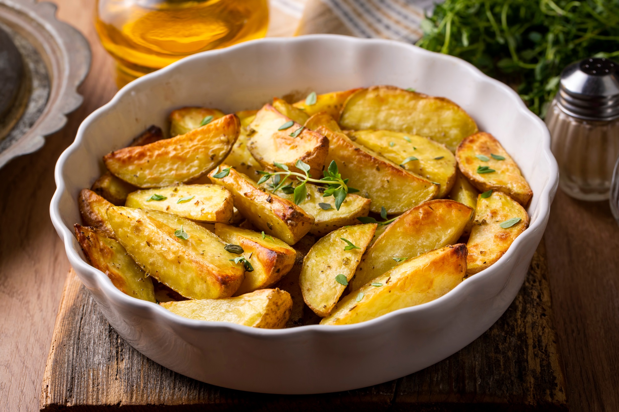 Pommes de terre au four, dorées et croustillantes, préparées dans l'airfryer, servies avec garniture.