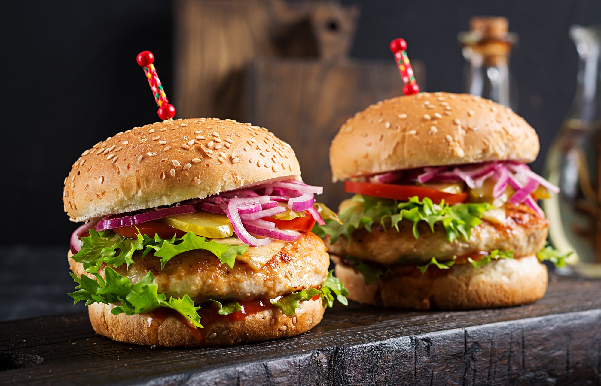 Un burger de poulet maison préparé dans l’airfryer, avec salade et tomate.