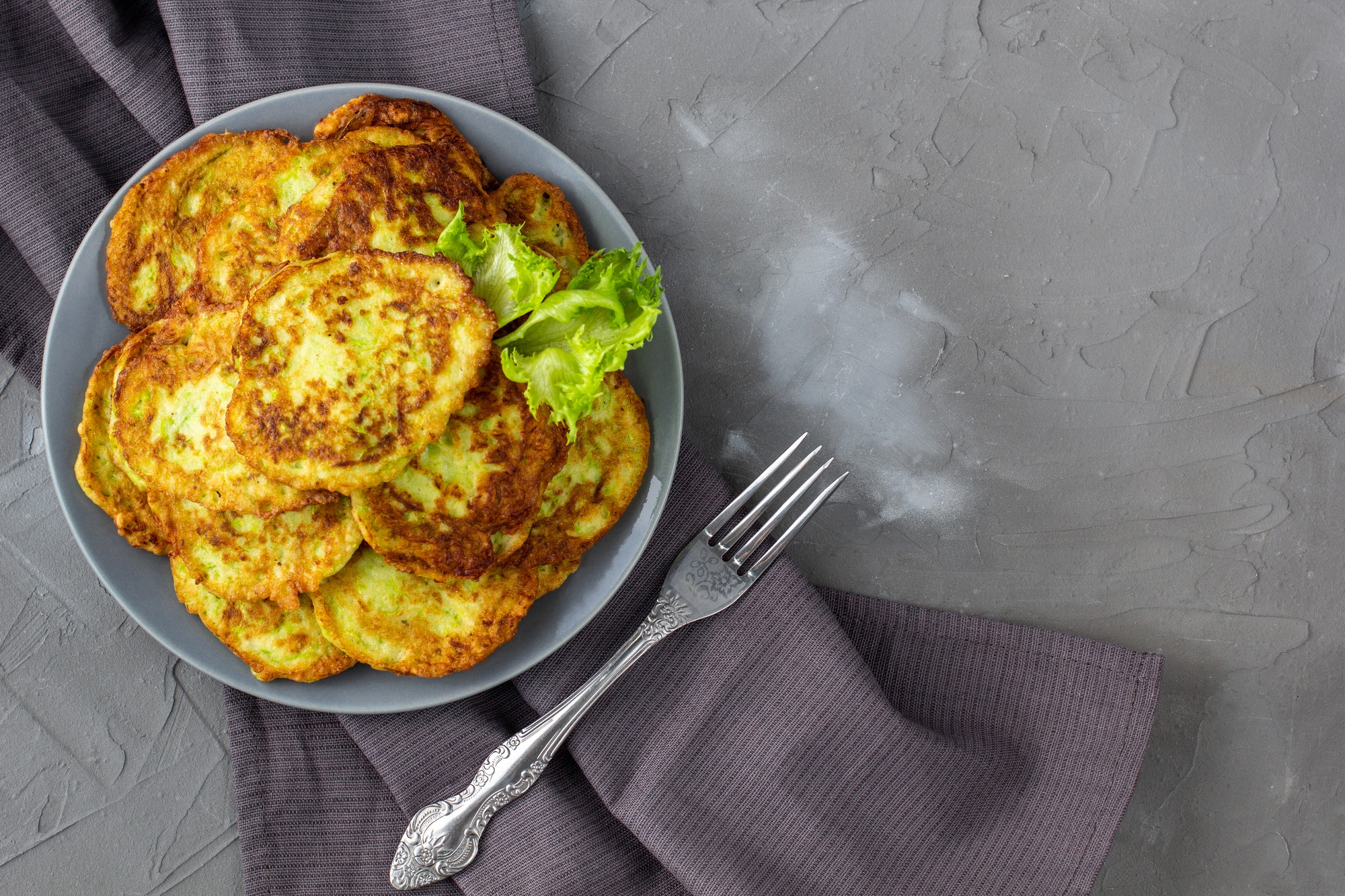 Rondelles de courgette dorées, cuites dans l'airfryer et servies dans une assiette.