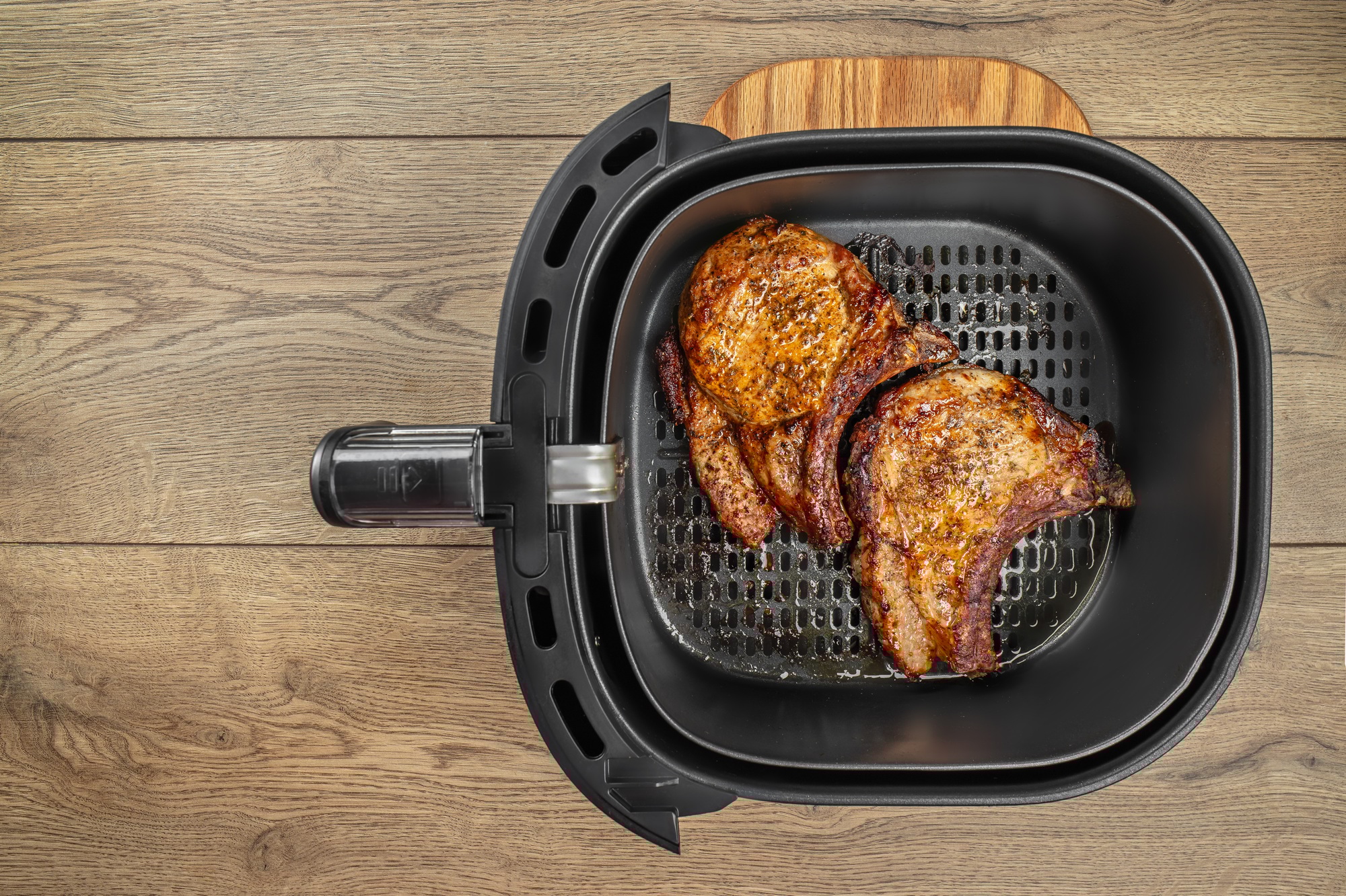 Bifteck juteux et doré cuit dans l'airfryer, servi avec des légumes.