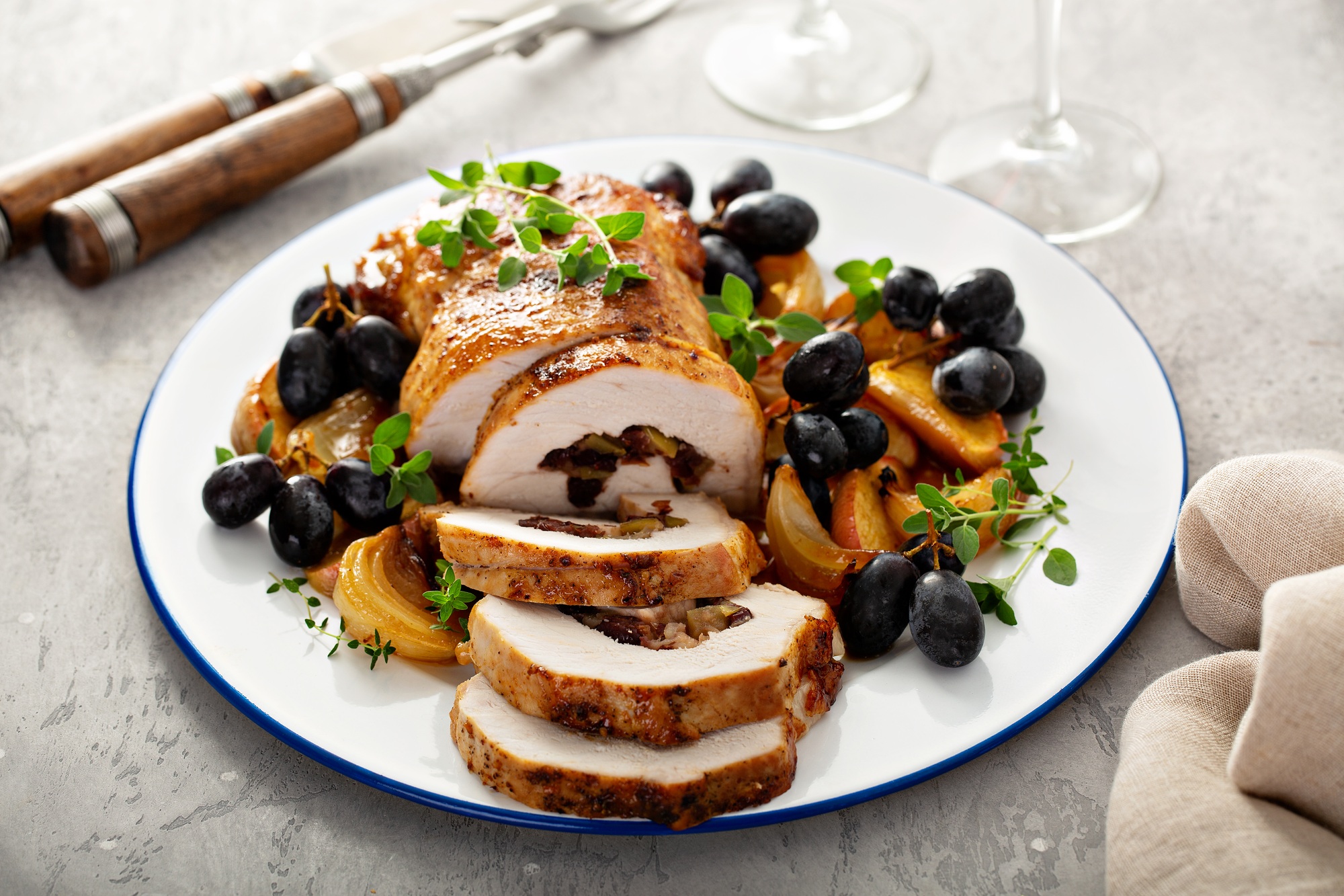 Rôti de porc doré cuit dans l’airfryer, tranché et servi avec des légumes.