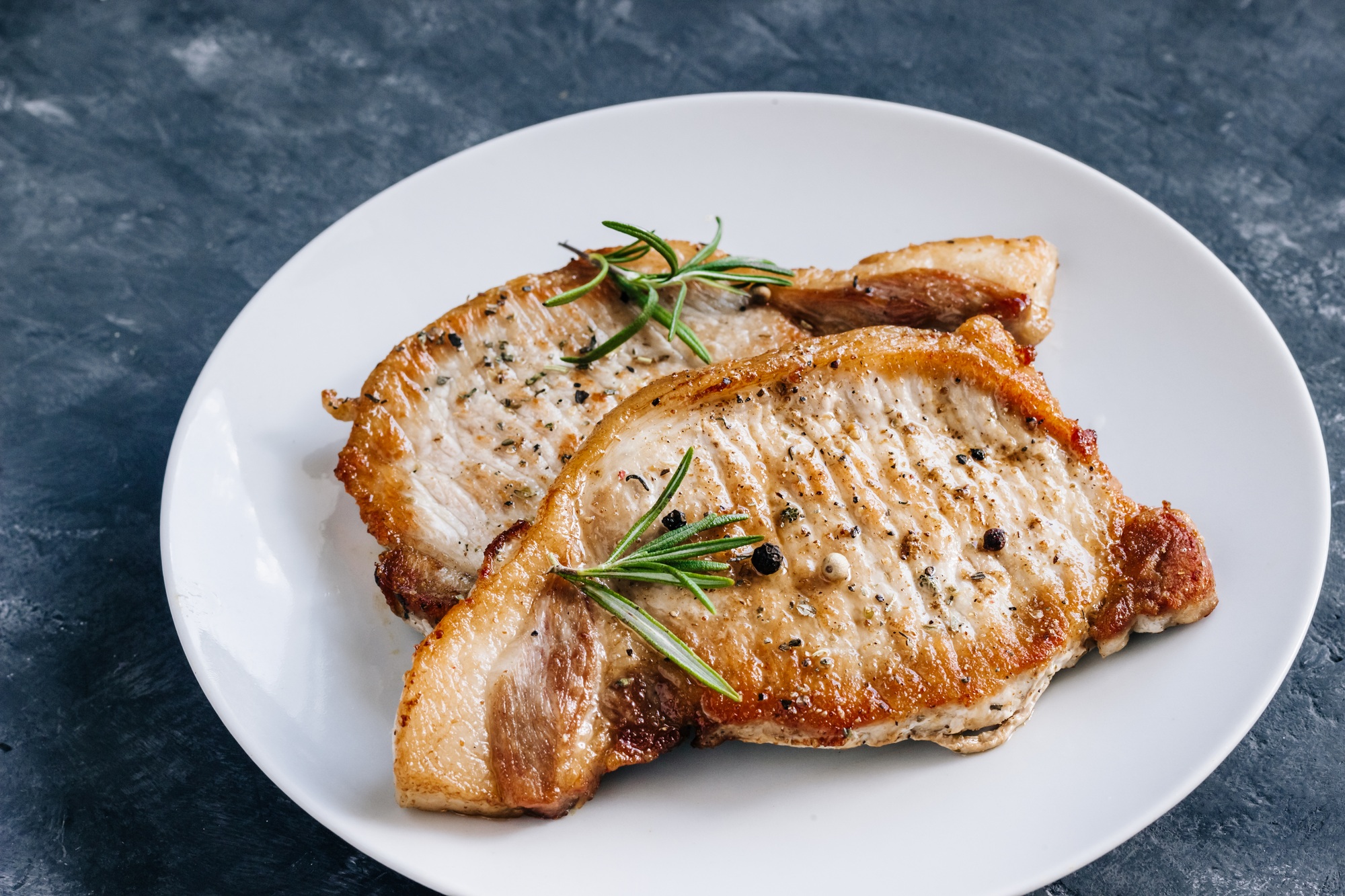 Rôti de porc fumé doré et juteux, tranché et servi avec des légumes.