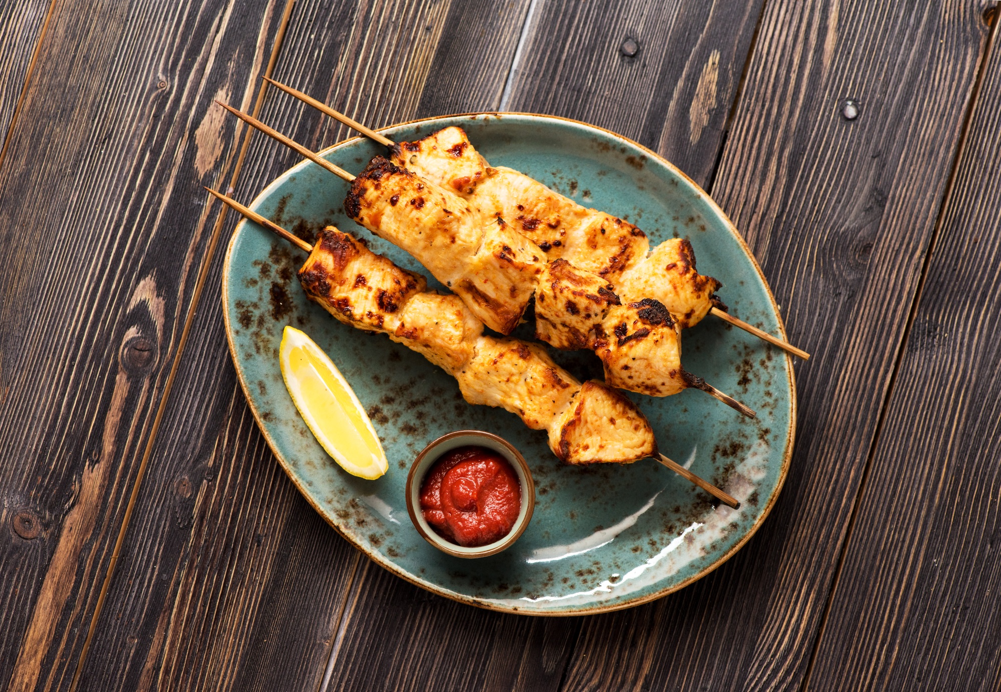 Brochettes de poulet cuites dans une airfryer avec des légumes colorés.