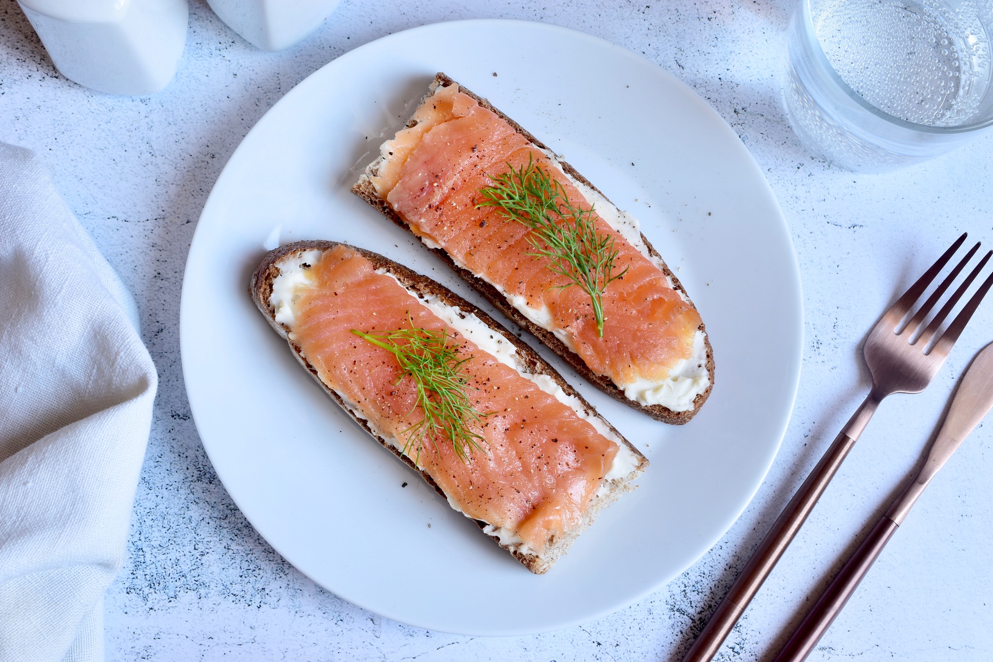 Tranches de saumon fumé réchauffées dans l’airfryer, servies sur un plat élégant.