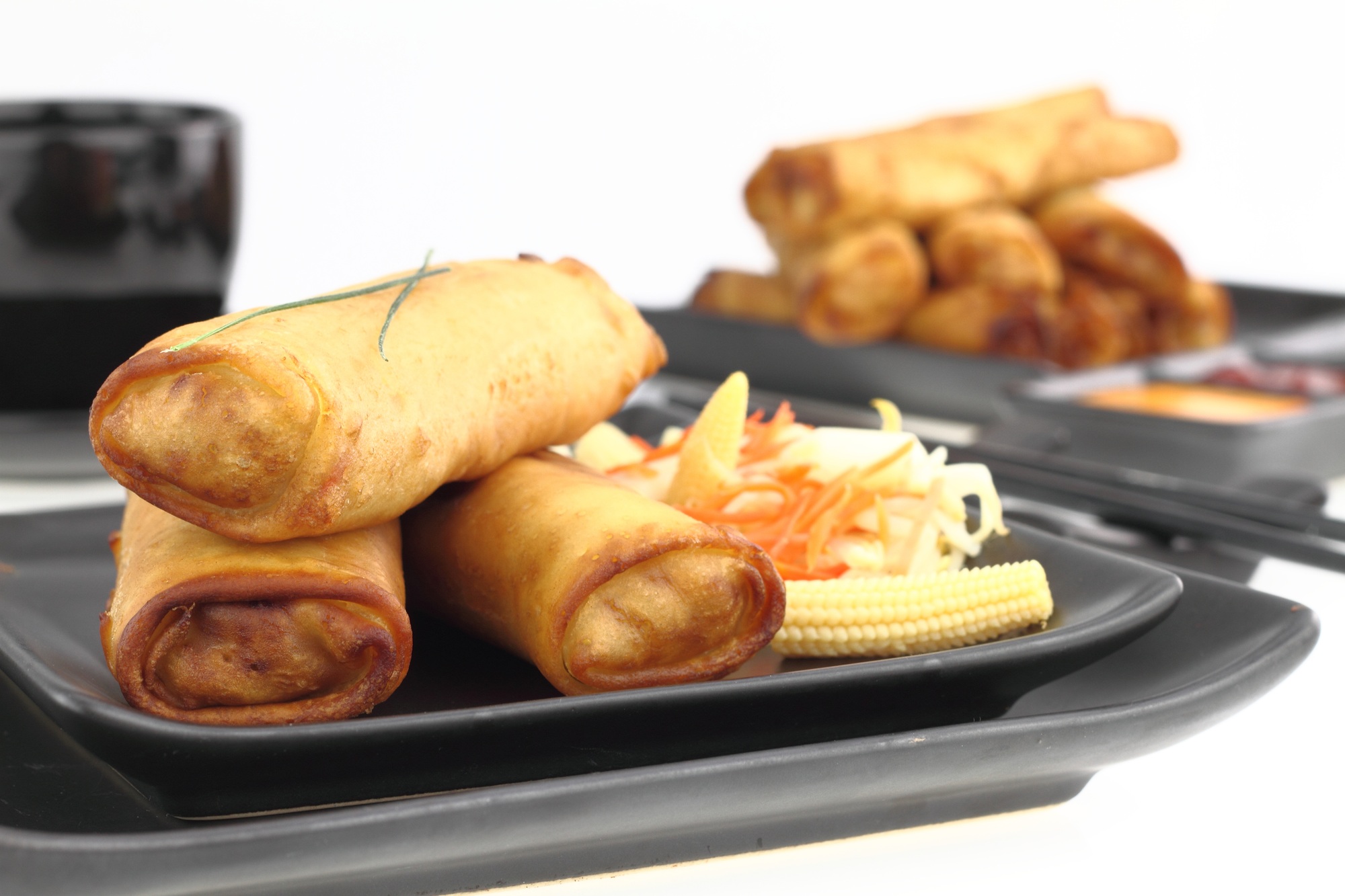 Rouleaux de printemps dorés cuits dans l'airfryer, servis avec une sauce.