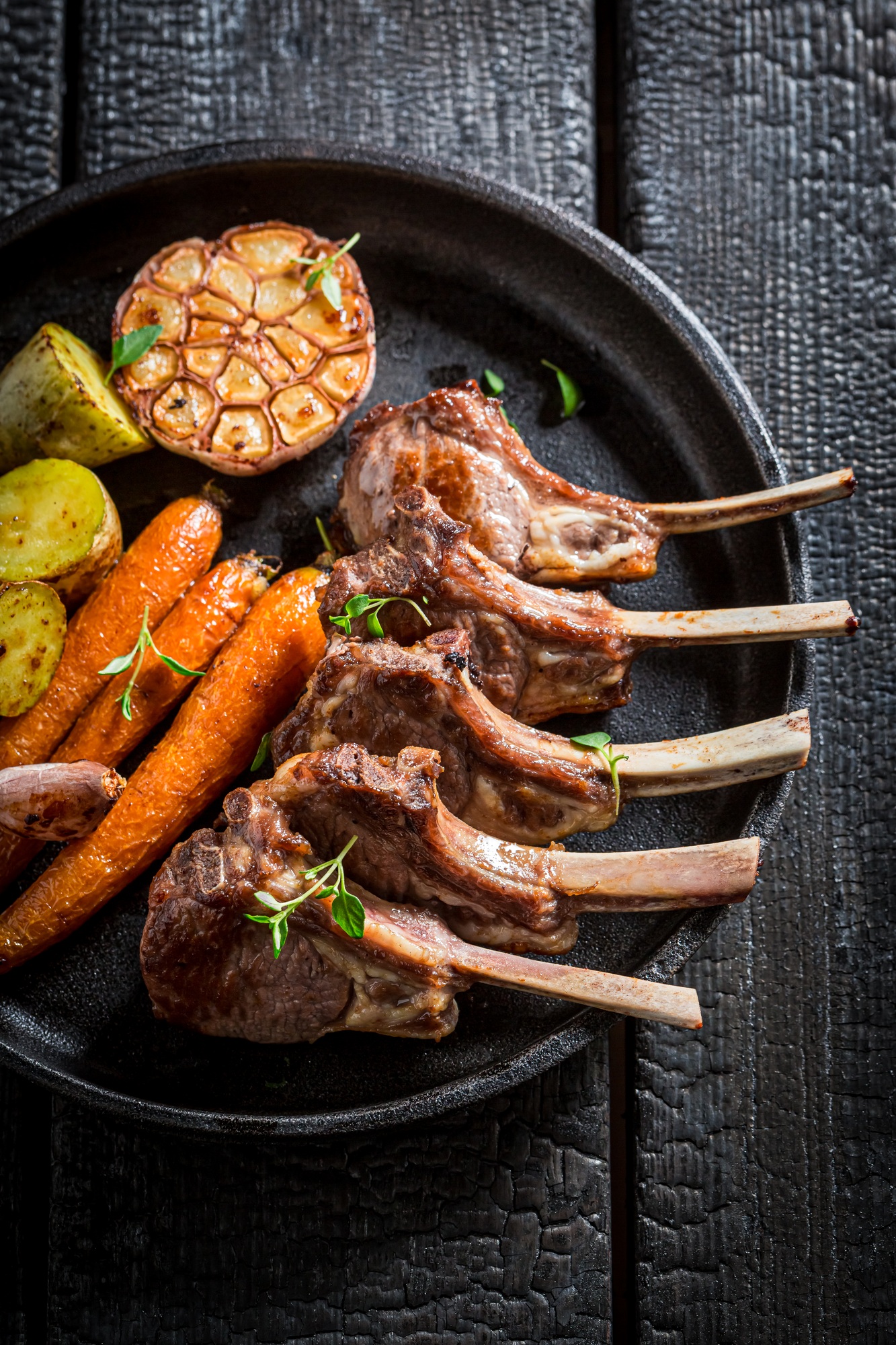 Côtelettes d'agneau dorées dans l’airfryer, accompagnées de légumes.
